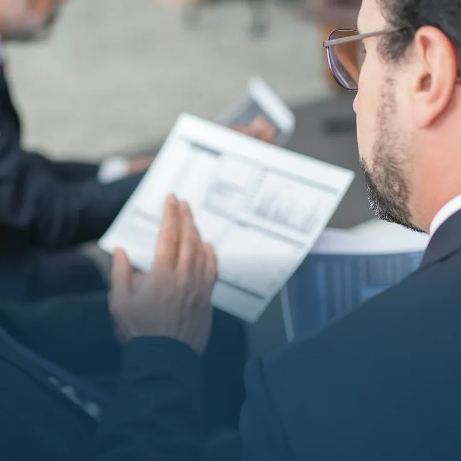 Two male employees discussing a financial graph, statement or budgets.