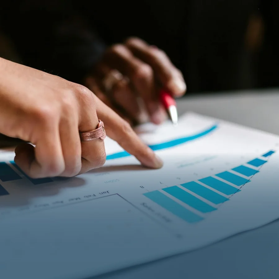 A close-up shot of a hand pointing towards changes in a report or audit sheet.