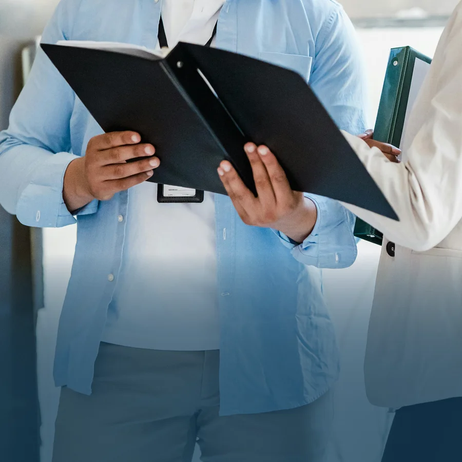 Two employees discussing the contents within an open file.