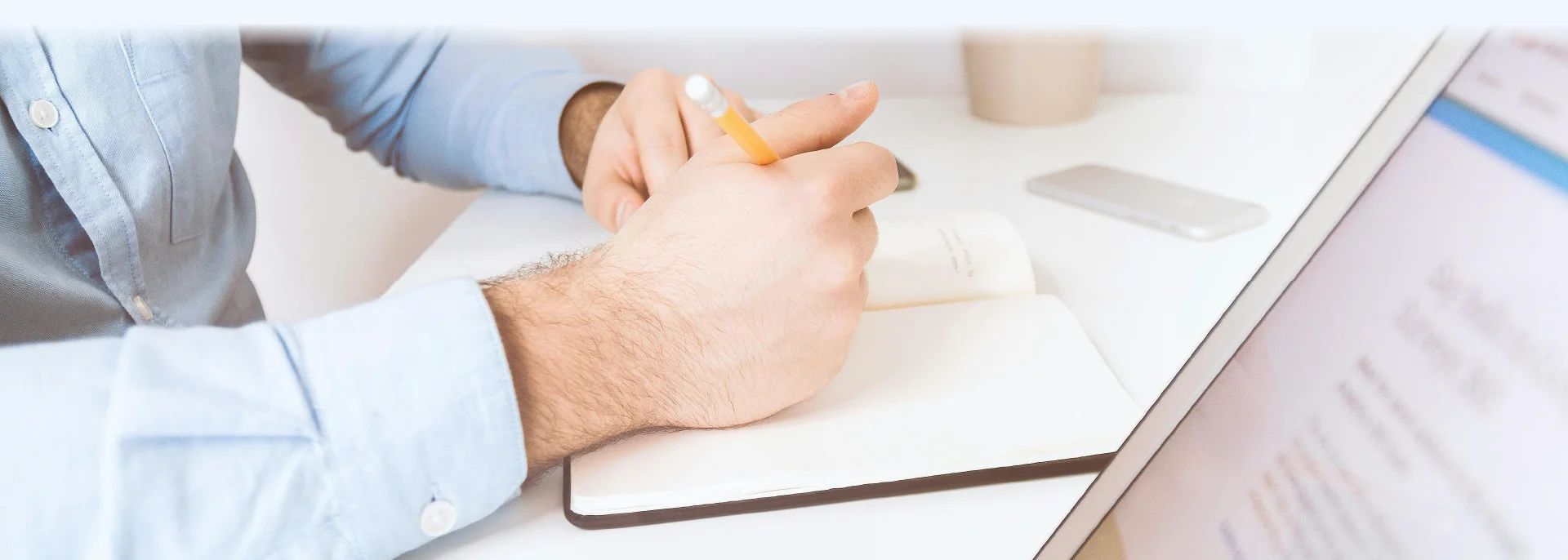 A man writing down notes on his notebook.