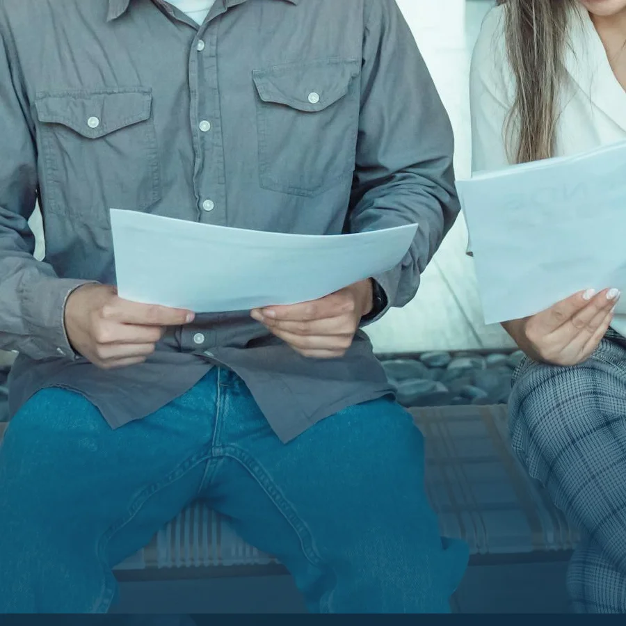 Two individuals holding their work permit or financial papers.